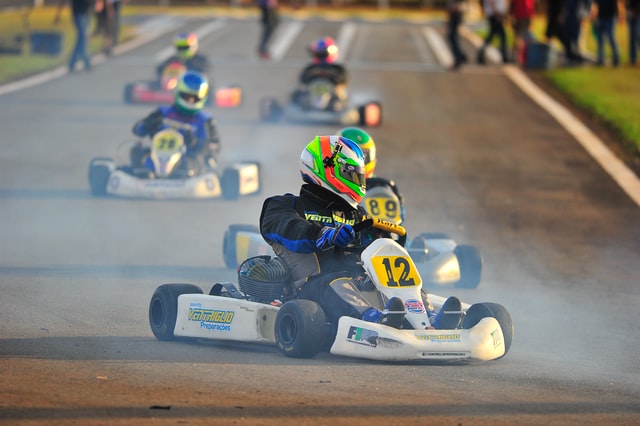 Company Outing; person driving a go-kart with other competitors in the background