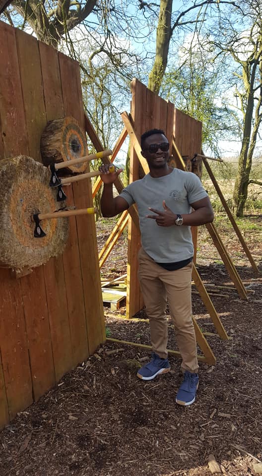 A man posing with an axe lodged in the log at Avalanche's Leicester Activity Centre