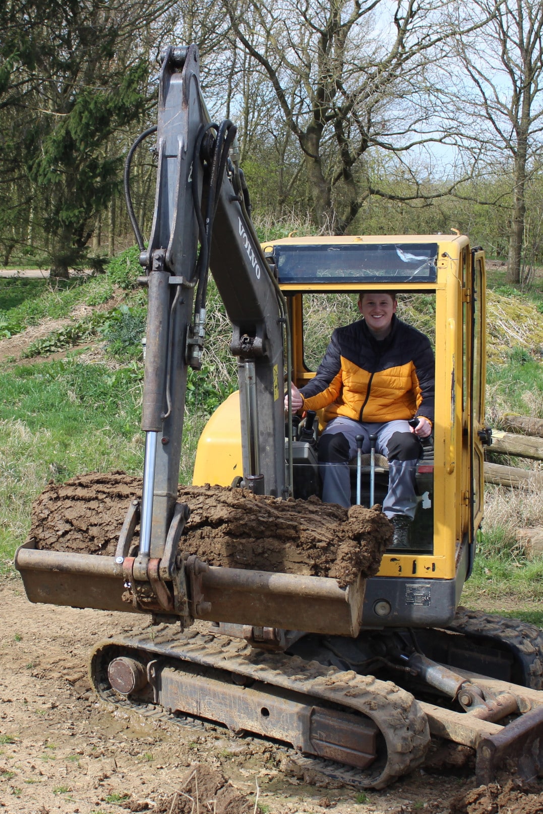 Outdoor activities for families; a man manoeuvring a yellow Volvo Digger