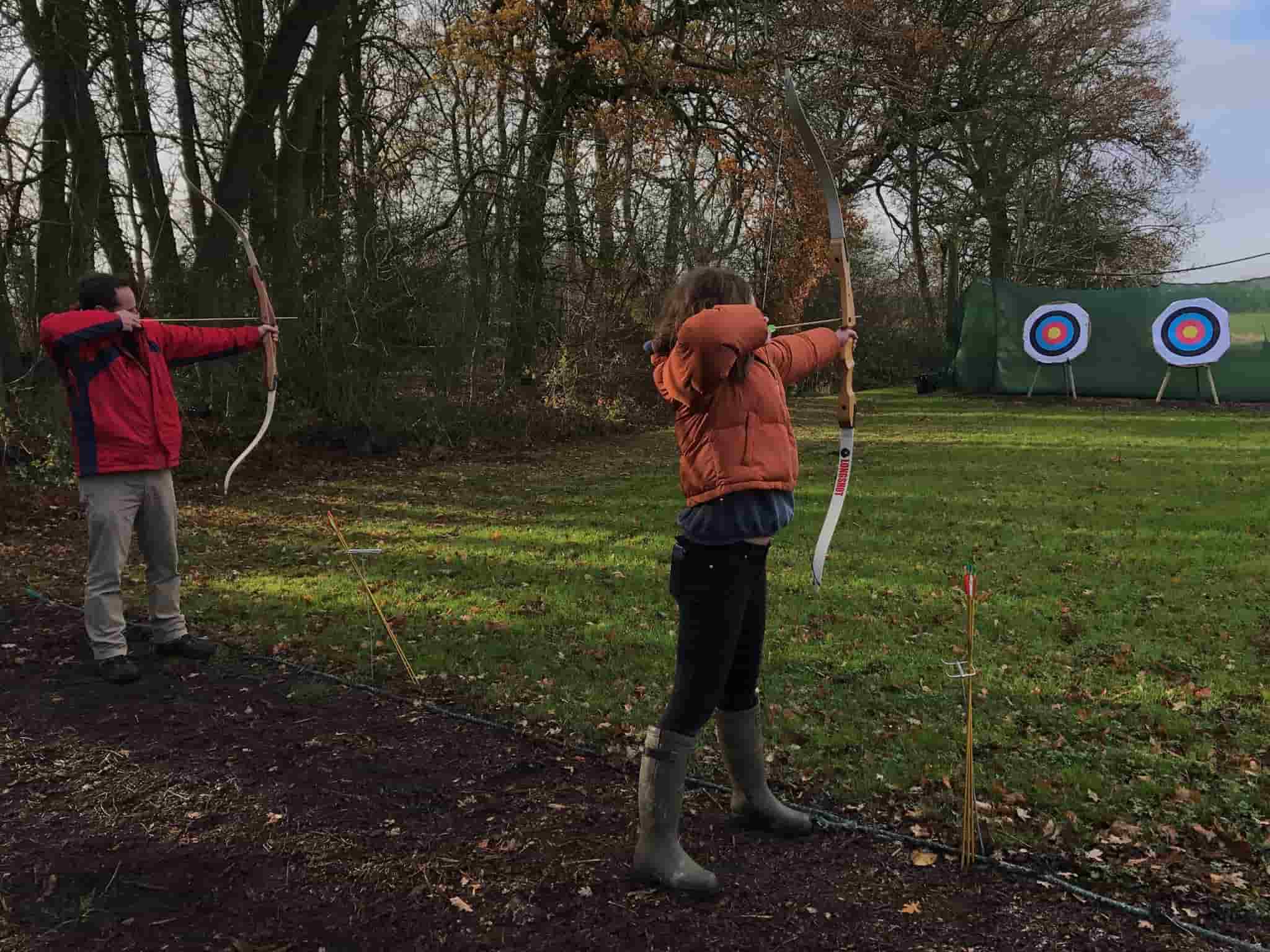 Happy Valentines day; two people holding a bow & arrow and aiming for the bullseye.